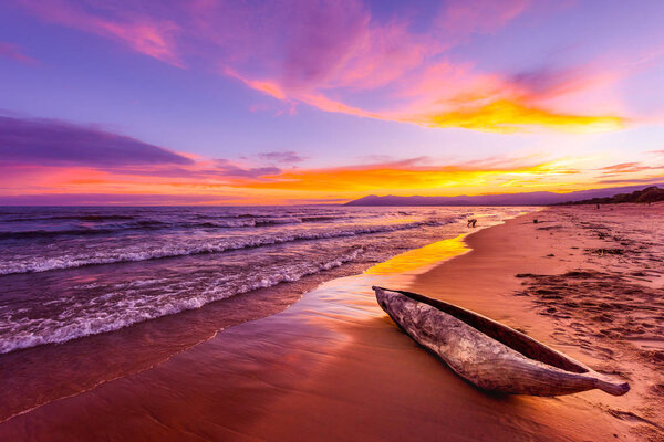 Lake Malawi sunset in Kande beach Africa, canoe boat on beach peaceful beach holiday beautiful sunset colors blue purple orange yellow in sky and clouds