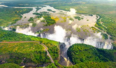 Victoria Falls Zimbabve ve Zambiya, hava helikopter fotoğraf, Afrika'nın muhteşem görkemli şelalenin çevresinde yeşil orman içinde. Livingston Köprü Nehri üzerinde