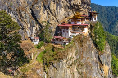 Tiger's Nest Monastery, Paro Taktsang, located high on a cliff in Paro, Bhutan, beautiful scenery and background of mountains and trees clipart