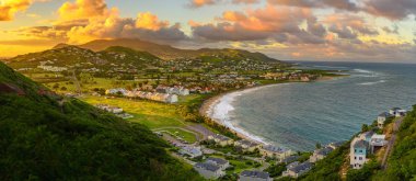 Saint Kitts ve sermaye Basseterre günbatımı, güzel yeşil dağlar ve şaşırtıcı yeşil ve turuncu renkler ile cennet Karayipler ada Beach'de sırasında Panoraması. Saint kitts ve nevis