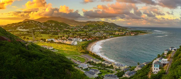 Saint Kitts ve sermaye Basseterre günbatımı, güzel yeşil dağlar ve şaşırtıcı yeşil ve turuncu renkler ile cennet Karayipler ada Beach'de sırasında Panoraması. Saint kitts ve nevis