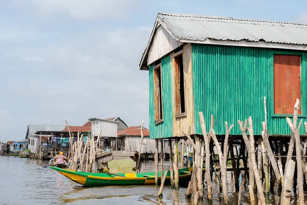 Lake house and boat. Benin lake Nokou lifestyle African villager living on house in water. Trading with barter system. West-Africa life in Benin living with boats on the lake.