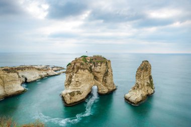 Rouche kayalar Beyrut, Lübnan'daki deniz kenarında ve gün batımı sırasında. Beyrut Lübnan'daki bulutlu gün.