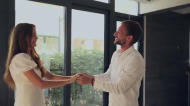 Modern evde el ele tutuşup dans eden romantik bir çift. 