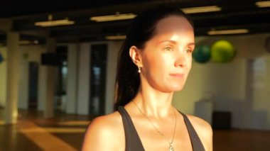 Yakından çekilen bir fotoğrafta spor salonunda güvenle yürüyen bir kız görülüyor. Odaklanmış adımları geniş bir pencereye doğru gidiyor..