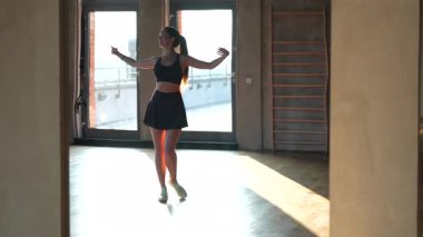 Koyu renk atletik giyinmiş genç bir kadın, tavan arası tarzı bir spor salonunda yoğun bir idmandan sonra büyük bir aynanın önünde kendine hayranlık duyar. Yüksek kalite 4k görüntü