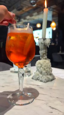 El ve mum ışığında turuncu kokteyl.