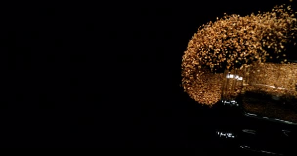 金色のセザム セサムナム指標 黒い背景に落ちている種子 スローモーション4K — ストック動画