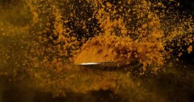 Koyu arkaplanda curcuma tozu sıçraması 