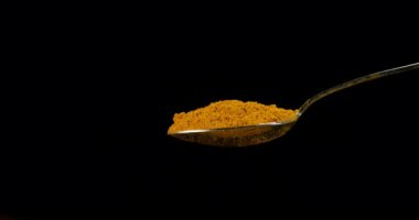 Koyu arkaplanda curcuma tozu sıçraması 