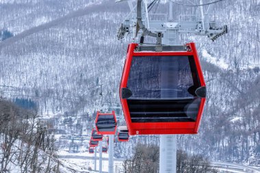 Ufuk satır kırmızı teleferik Asansör kabin Krasnaya Polyana kayak dağ merkezinde. Gondol closeup görünümü kış, karlı dağ zemin üzerine