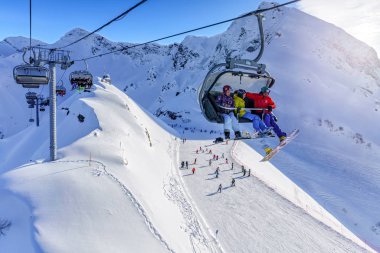 Sochi, Rusya - 7 Ocak 2018: Kayakçılar ve kayak pisti ve sandalye teleferik Gorki Gorod dağ kayak merkezi karlı dağ tepe ve mavi gökyüzü karşı sürme yatılı doğal güneşli kış manzara.