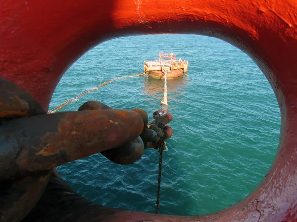 Offshore oil loading from single buoy mooring into oil tanker. Single buoy mooring serves as mooring point for tankers loading and offloading gas and liquids