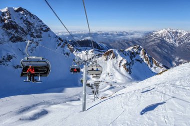 Sochi, Rusya Federasyonu - 20 Ocak 2013: Karlı Aibga dağ cirque Kayak tesisi ve sandalye teleferik Gorki Gorod kış kayak dağ altında mavi gökyüzü güneşli günde çare. Doğal Kafkas Dağları manzara.