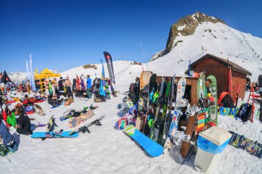 Sochi, Russia - March 25, 2014: Quiksilver NewStar Camp is winter mountain sports and entertainment hangout for skiers and snowboarders. Many people chill out relaxing apres ski on snow on sunny day clipart