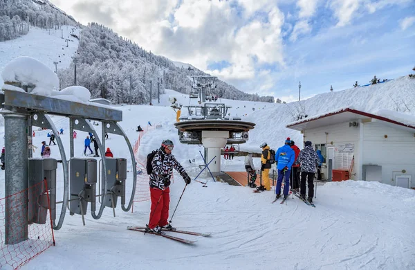 Sochi, Rusya Federasyonu - 9 Ocak 2015: Bir kayakçı için yatılı bir sandalye teleferik üzerine turnike Gorki Gorod kış dağ kayak merkezi içinde geçti. Teleferik gezmeye kayakçı sıraya