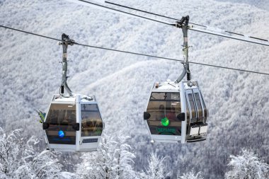 Soçi, Rusya - 9 Ocak 2015: teleferik teleferik, Gorki Gorod kış dağ kayak merkezinde. Karlı zemin üzerine iki kabin görünümü kapatın