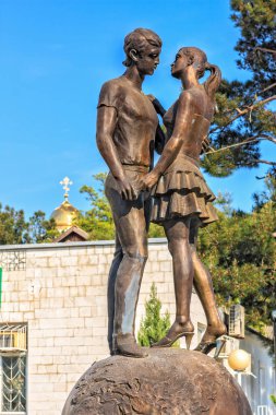 Gelendzhik, Rusya - 2 Mayıs 2008: Bronz heykel gençler bir küre üzerinde kalma bir duran ve aşk görüntüleme. Saint Sevgililer günü simgesi. Mavi gökyüzü ile dikey görünüm