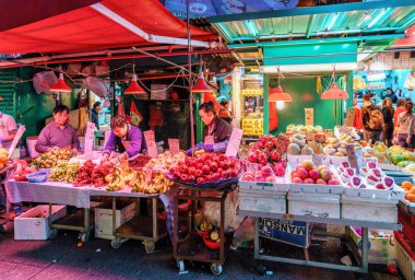 Hong Kong, Çin - 18 Ocak 2016: Asya tarım Pazar olgunlaşmış taze meyve farklı türlü ile doludur. Hong Kong sokak pazar gece manzarası. Onların shopboards satıcılar vardır