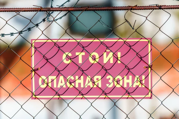 Tehlikeli bölge uyarı işareti gün batımında barbwire ile korkuluk kumaşı metal durdurmak