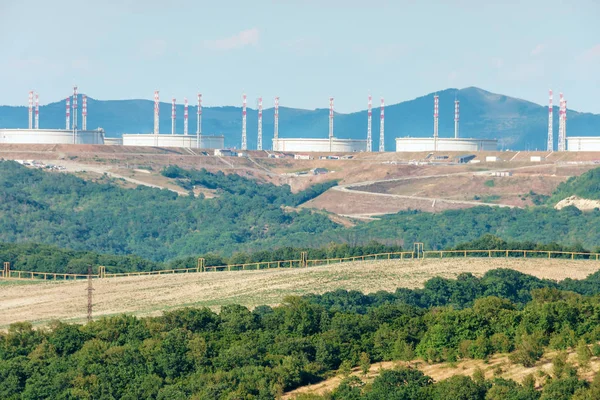 Kafkasya dağ eteklerinde ve petrol tankları ve petrol taşıma şirketindiğer endüstriyel altyapı güneşli manzara - Hazar Boru Hattı Konsorsiyumu ufukta