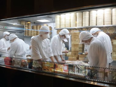 Hong Kong, Çin - 14 Ocak 2016: Çin restoranının mutfağı sokaktan pencereden görüntülendi. Erkekler yemek pişirir.