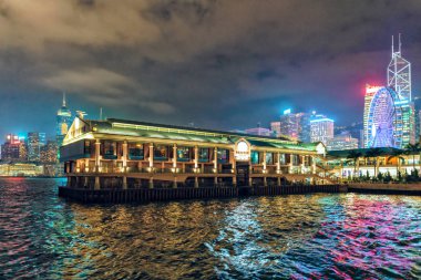 Hong Kong Denizcilik Müzesi manzarası. Şehir silüeti ve renkli su yansımaları ile Aydınlatılmış manzara dramatik gece manzarası