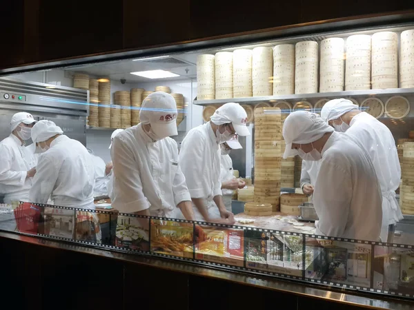 Hong Kong, Çin - 14 Ocak 2016: Çin restoranının mutfağı sokaktan pencereden görüntülendi. Erkekler yemek pişirir.