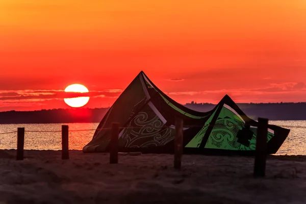 Cometa descansando en la playa de arena al atardecer. Anapa es destino de kitesurf en Rusia —  Fotos de Stock