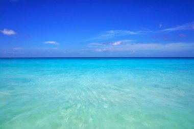 Doğal deniz masmavi şeffaf okyanus su ve mavi gökyüzü. Tropikal plaj beyaz kum ile. Tatil beldesi pastoral toplayan. Tatil ve tatil için egzotik seyahat hedef