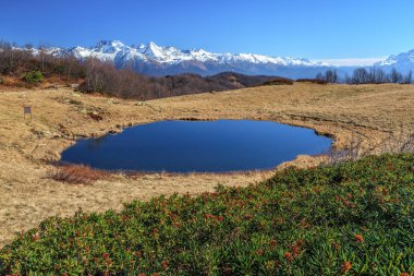 Üst Khmelevskoye Gölü karlı Kafkaslar Dağı zirveleri ve açık mavi gökyüzü arka plan üzerinde Zerkalnoye çağırdı. Doğal sonbahar güneşli gün manzara. Soçi, Rusya Federasyonu