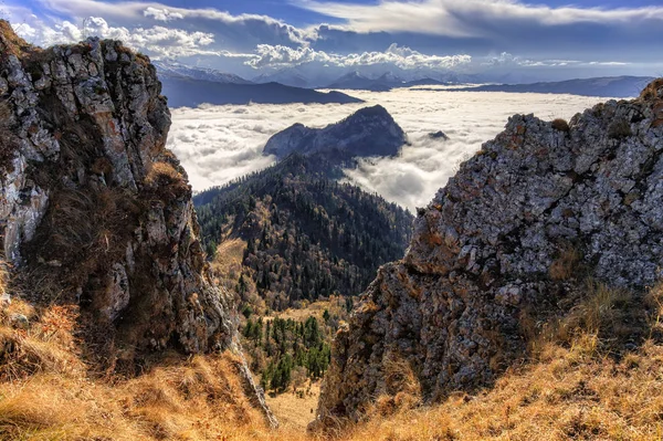 Bela paisagem cênica outono de Afonka Rock visto a partir de Maliy Tkhach pico da montanha com mortalha de nuvens baixas dispersas. West Caucasus, Adygea Republic, Rússia — Fotografia de Stock