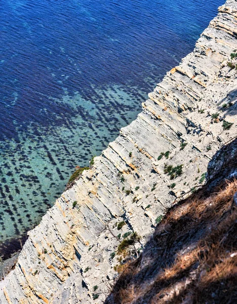 Hermoso paisaje panorámico soleado de la costa del Mar Negro en verano. Paisajes costeros con fondo marino visto a través de agua azul clara y acantilado rocoso empinado en primer plano. Dzhankhot, Gelendzhik . —  Fotos de Stock