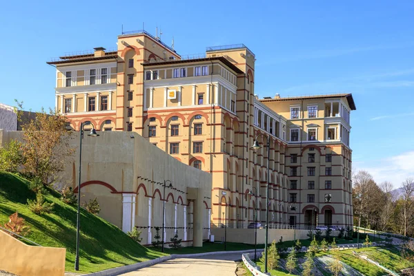 Sotchi, Russie - 21 octobre 2014 : Belle vue extérieure ensoleillée d'automne du Novotel Resort Krasnaya Polyana Sotchi Hotel building in Gorky Gorod resort in Caucasus mountains under blue sky . — Photo