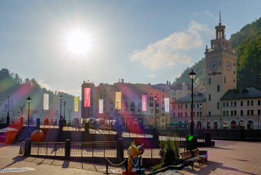 Soçi, Rusya - 30 Temmuz 2014: Kafkas dağlarında Rosa Khutor dağ kayak merkezinin güzel gün batımı şehir manzarası. Ana meydan ve kule görünümü.