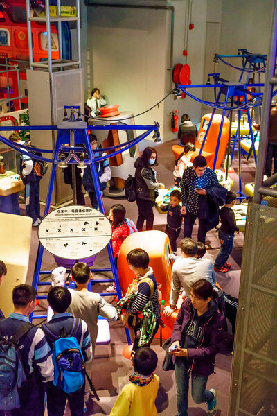 Hong Kong, China - January 20, 2016: Tourists crowding in Hong Kong Science Museum. People study attractions emulating various physical phenomena. Interior view.
