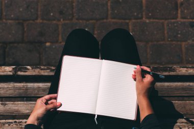 Boş bir defter kadın ellerindeydi. Kalemle birlikte. Parkta bir bankta oturuyordu. Bir kadının elleri defteri tutuyor. Bütün rüyalarını bir deftere yaz. Kalemle el yazısı. Uzay metni