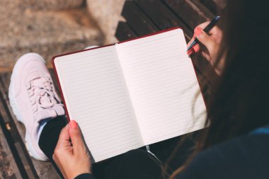 Genç bir kadın elinde kalemle parktaki bankta oturuyor. Dilek Maratonu. Bir deftere dilek ve rüya yazıyorum. Temiz bir sayfa açarak. Mesaj için yer var. Arzuların hakkında düşünceler
