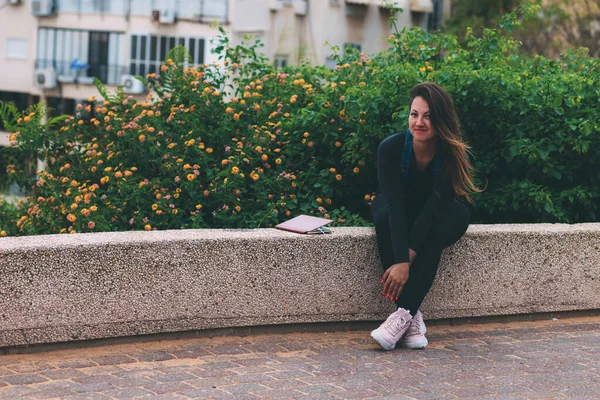 Jonge Vrouw Het Park Zit Een Stenen Bank Naast Een — Stockfoto