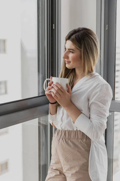 Młoda Piękna Kobieta Pobliżu Okna Filiżanką Kawy Lub Herbaty Domu — Zdjęcie stockowe