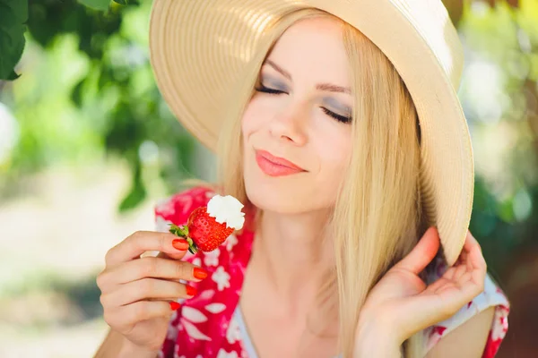 年轻的金发女人吃草莓奶油 在花园里快乐的夏日阳光明媚的一天 温暖的夏日滋补形象 自助和健康的生活方式 — 图库照片