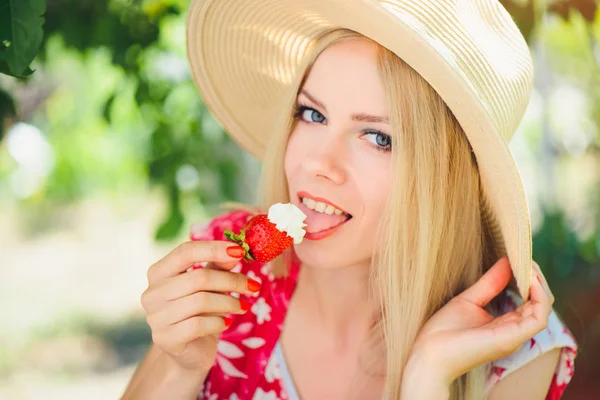年轻的金发女人吃草莓奶油 在花园里快乐的夏日阳光明媚的一天 温暖的夏日滋补形象 自助和健康的生活方式 — 图库照片