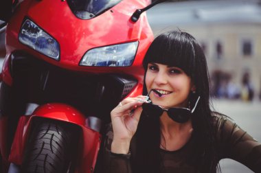 motosiklet ve mutlu, yakın çekim esmer kırmızı bisiklet ile oturan mutlu kadın motorcu.