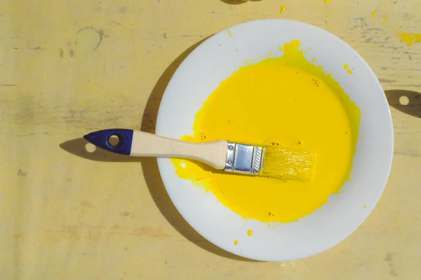 Gelbe Farbe Auf Weißem Teller Mit Pinsel Auf Altem Tisch — Stockfoto