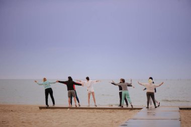 Grup yoga, sağlıklı bir yaşam tarzı yaparken şafakta, egzersizleri yapıyor insan.