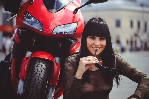赤いバイク オートバイと幸せ クローズ アップのブルネットのそばに座って幸せな女性バイカー — ストック写真