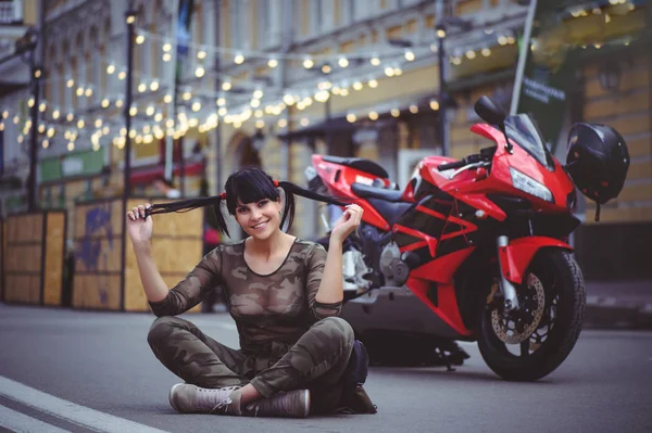 赤いバイク オートバイと幸せ クローズ アップのブルネットのそばに座って幸せな女性バイカー — ストック写真