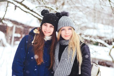 komik ve mutlu iki güzel kız arkadaşım kış aylarında kar ve kış kıyafetleri çok yürümek. sarışın ve esmer duygular.