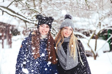 komik ve mutlu iki güzel kız arkadaşım karda kışın çok kar ve kış giysi oynamak. sarışın ve esmer duygular.