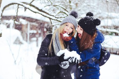 Yaratıcı komik ve mutlu iki güzel kız kar kar kış aylarında kar ve kış kıyafetleri çok oynamak. komik yaramaz reklam.